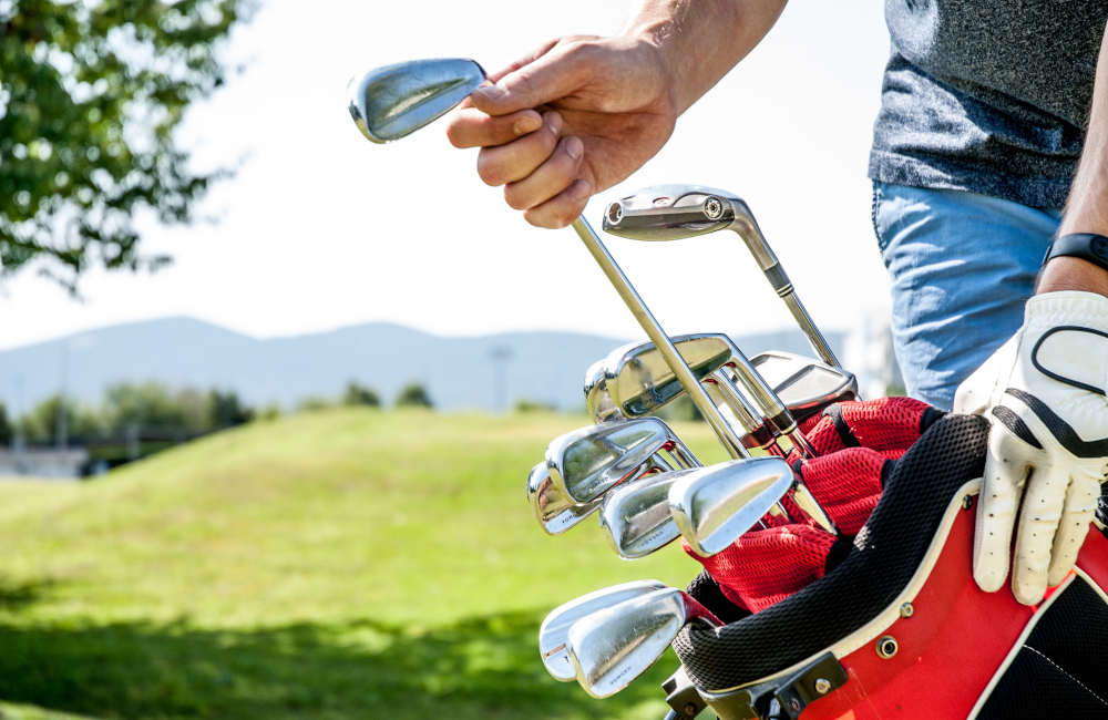 Golfer Pulling Out a Golf Club From Red Golf Bag